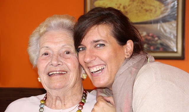 Seniorin lacht gemeinsam mit ihrer Tochter